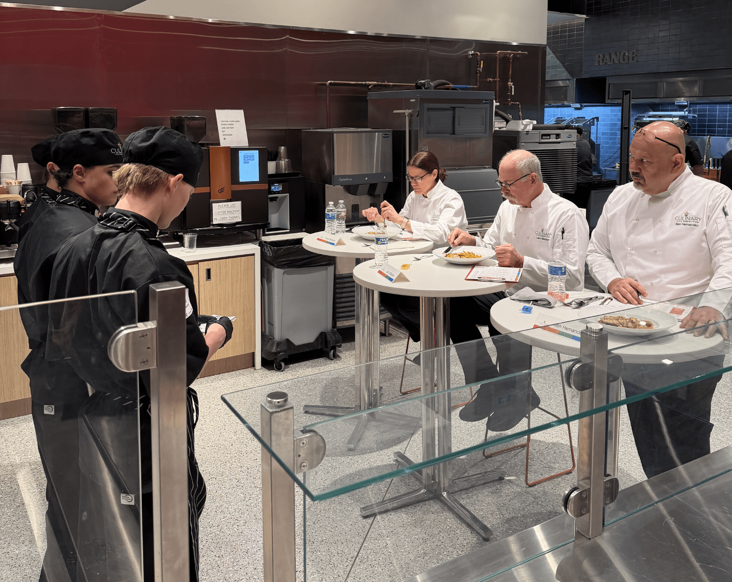 Chefs judging student dishes. 